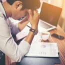 Small Business Cash Flow Management Small Business Cash flow stress, man in front of documents and laptop.